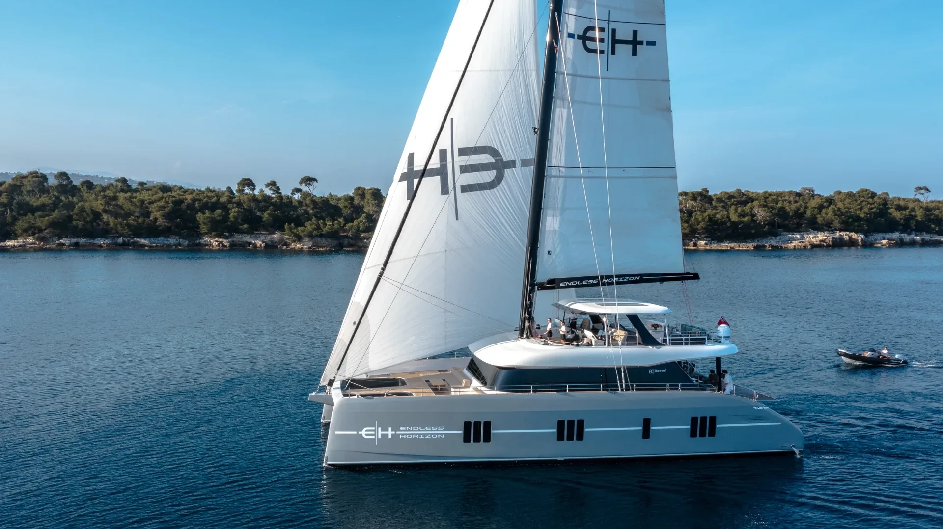 Under full sail past the Lerins pines with the EH mark on the main