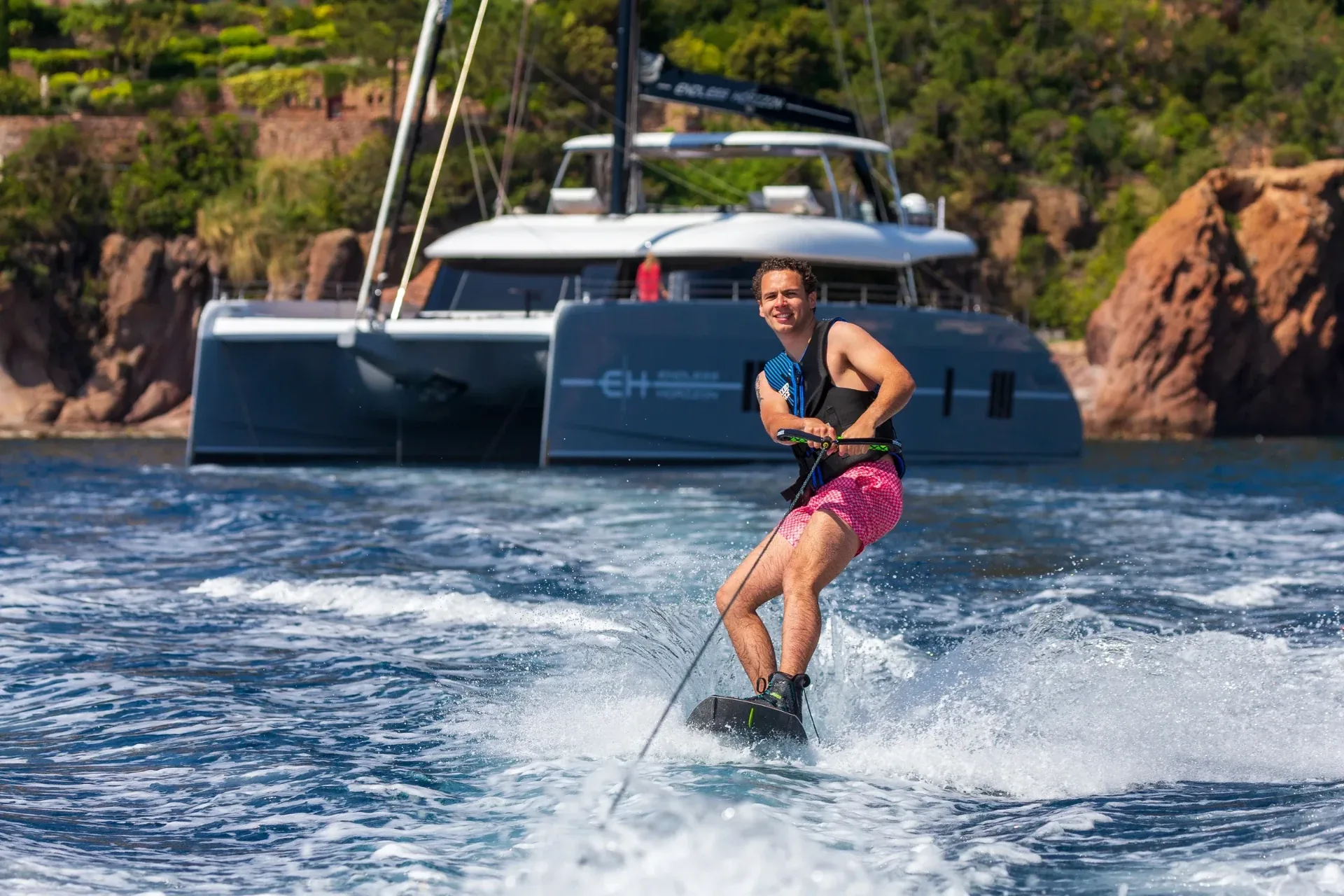 Guest wakeboarding on tow with Endless Horizon II in the background