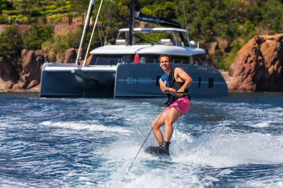 Guest wakeboarding on tow with Endless Horizon II in the background