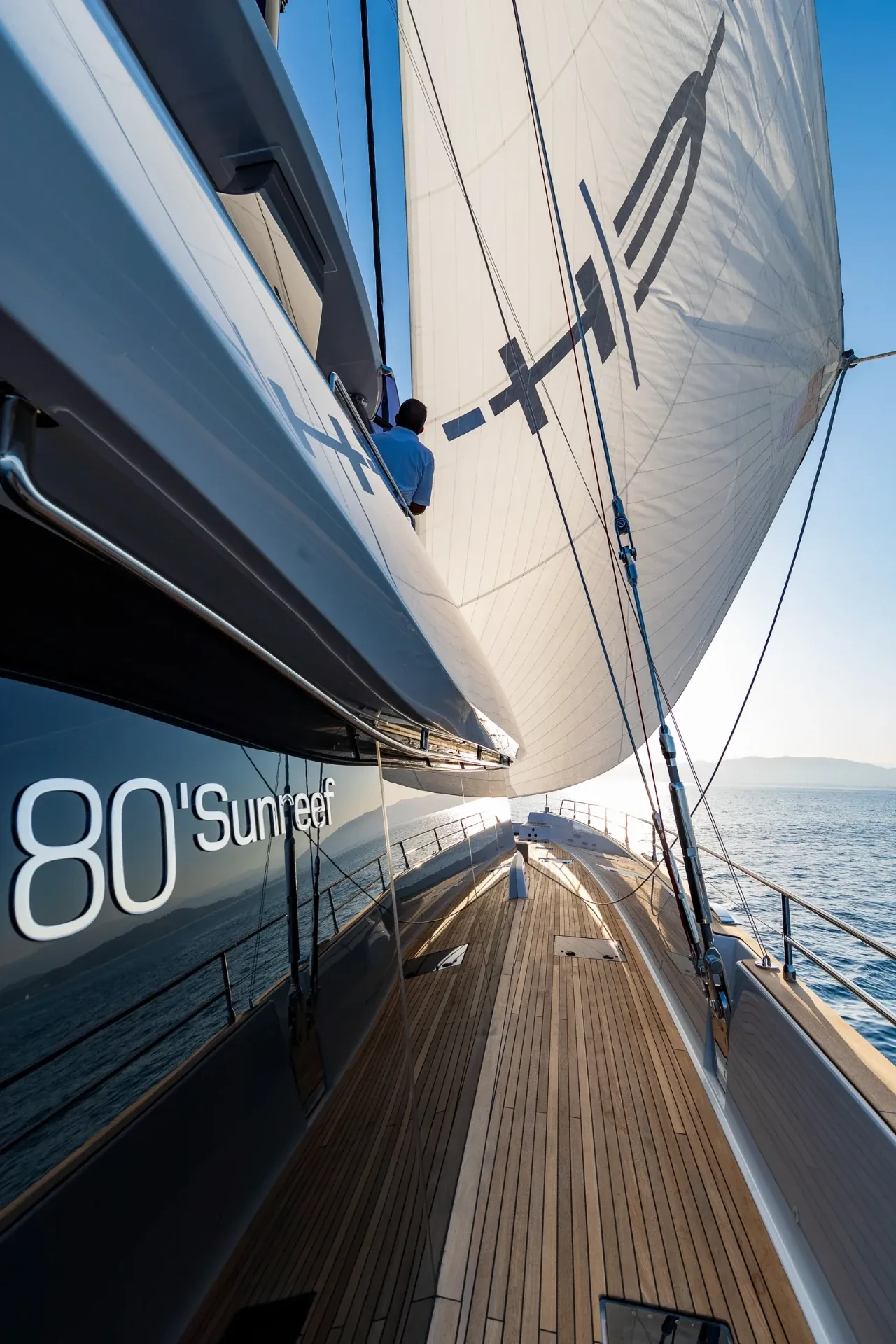 Sunreef 80 hull graphic along the side deck with crew tending the rig