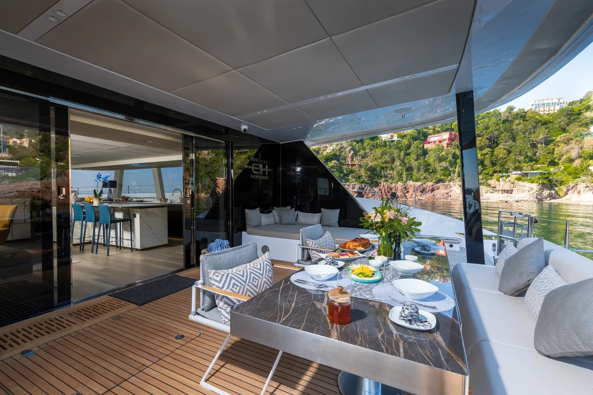 Breakfast laid on the shaded cockpit table with the galley bar beyond