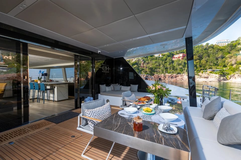 Breakfast laid on the shaded cockpit table with the galley bar beyond