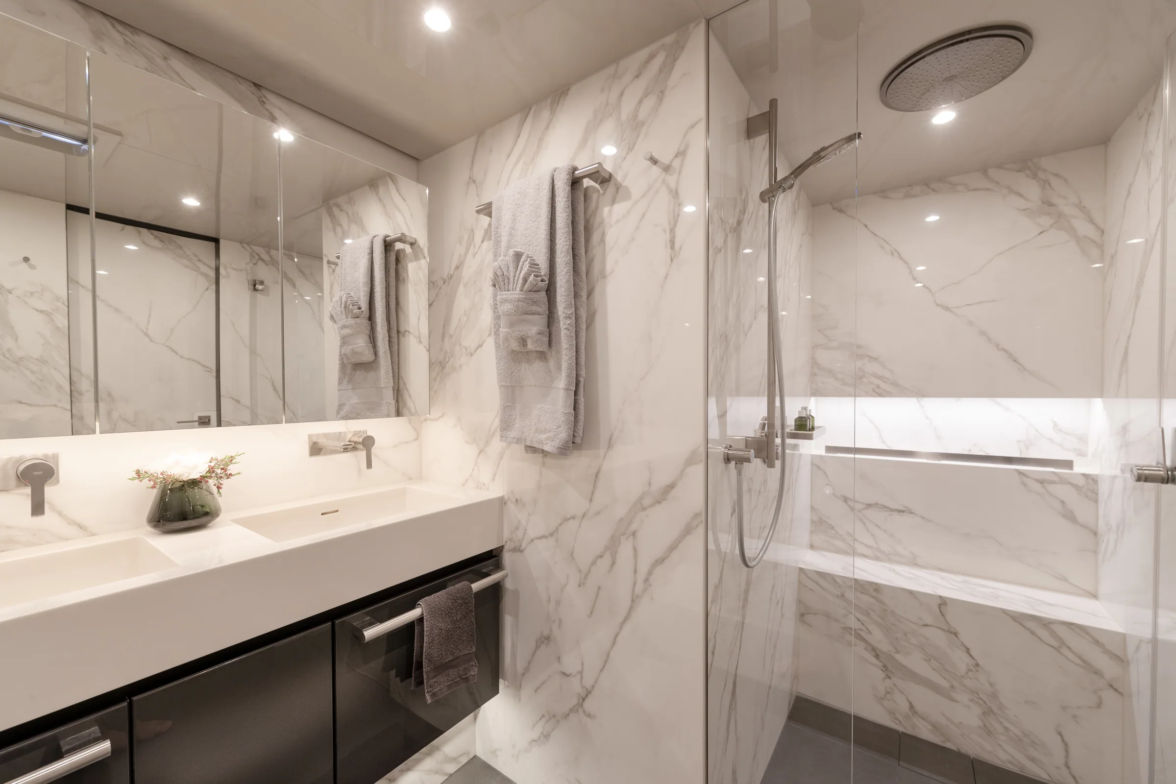 Marble ensuite head with a walk-in shower and twin basins