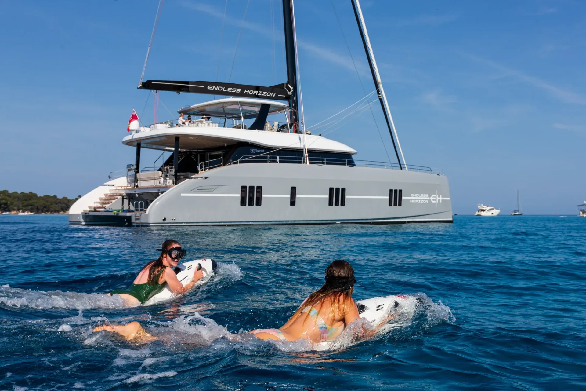 Two guests running Seabobs side by side beside the catamaran