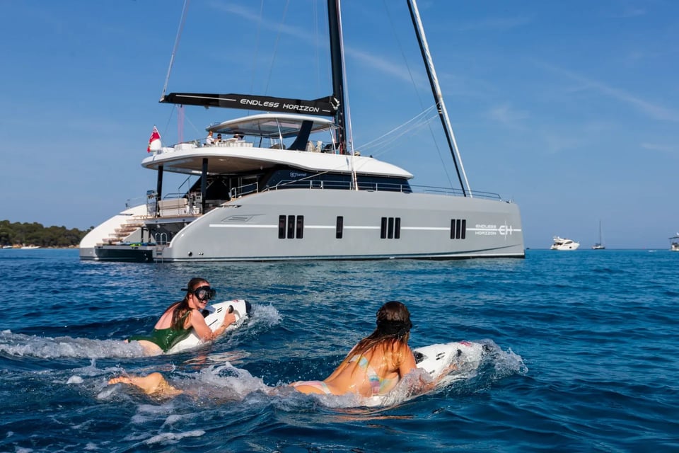 Two guests running Seabobs side by side beside the catamaran