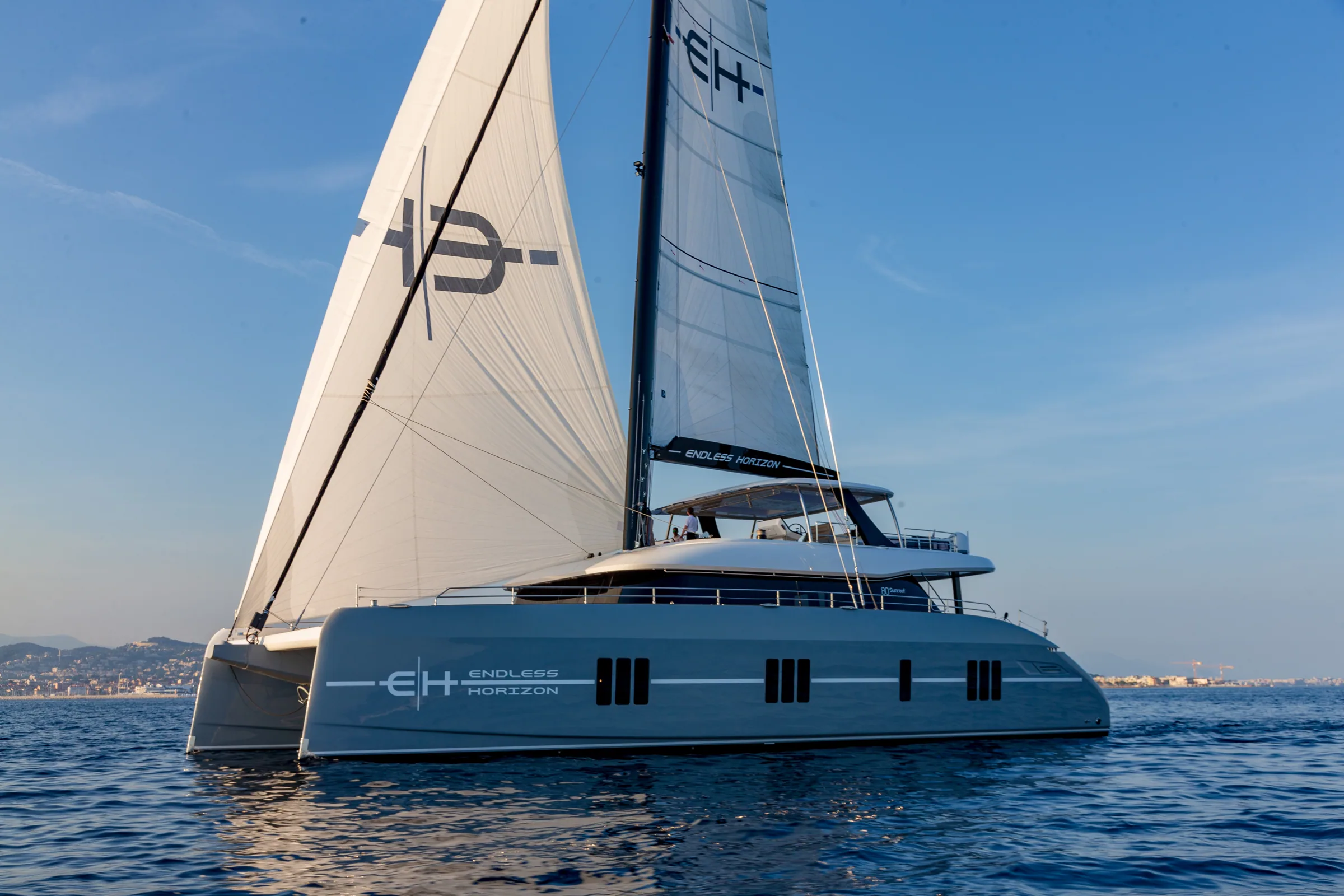 The Sunreef 80 Endless Horizon II sailing on flat blue water, mainsail and headsail set