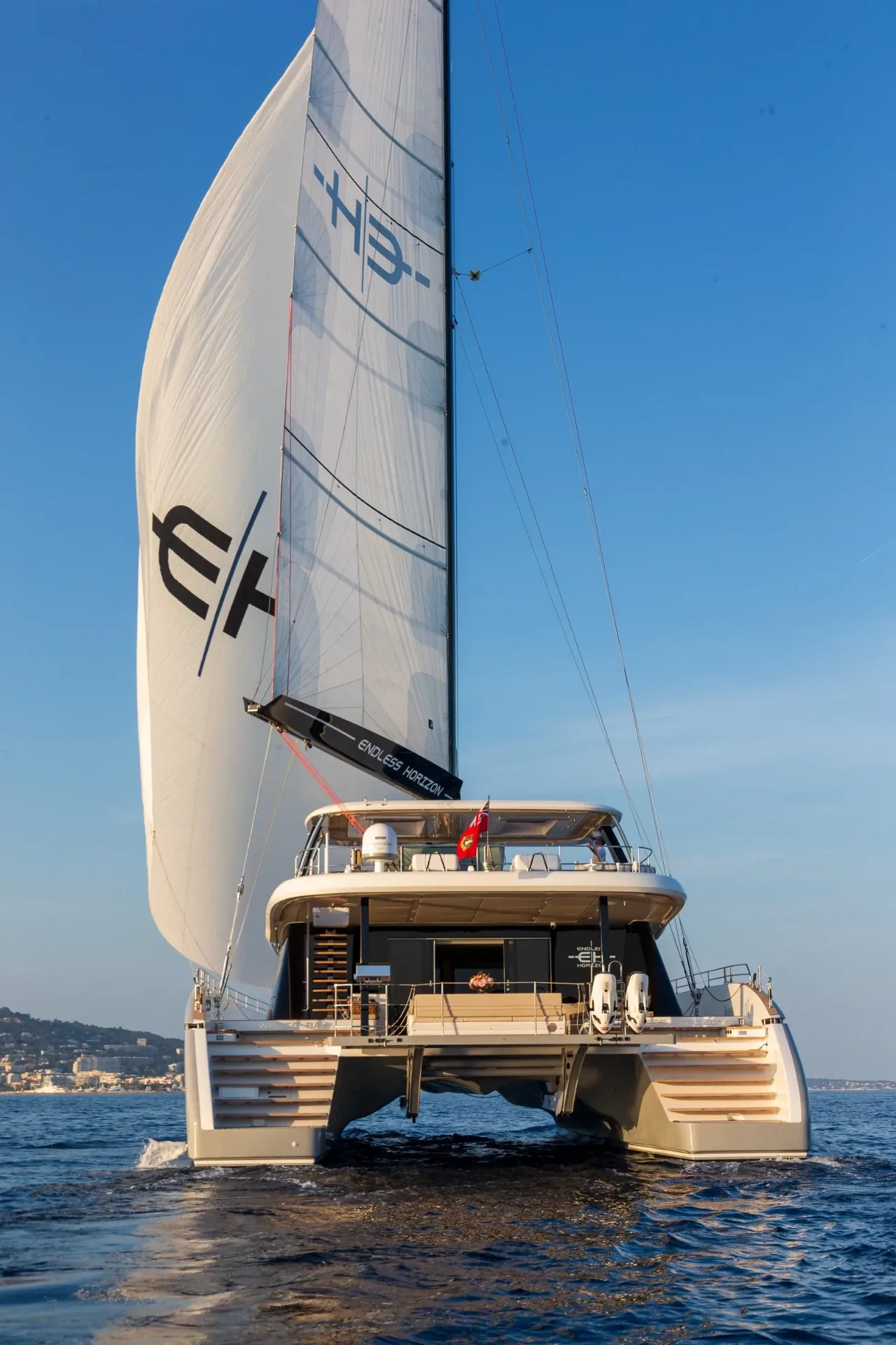 Full-height stern view of Endless Horizon II under sail with the EH insignia aloft