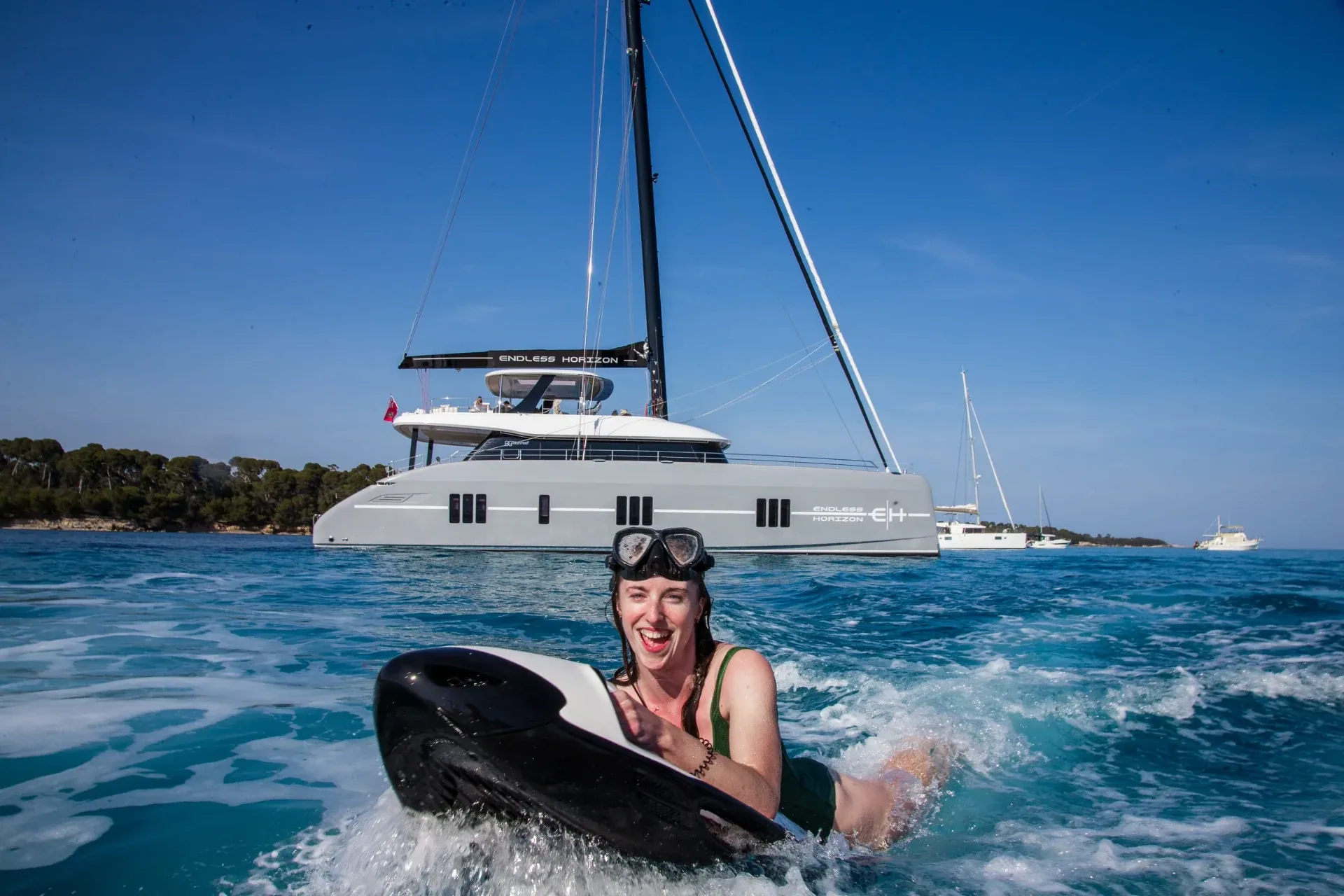 Guest riding a Seabob past the yacht at anchor off the Lerins