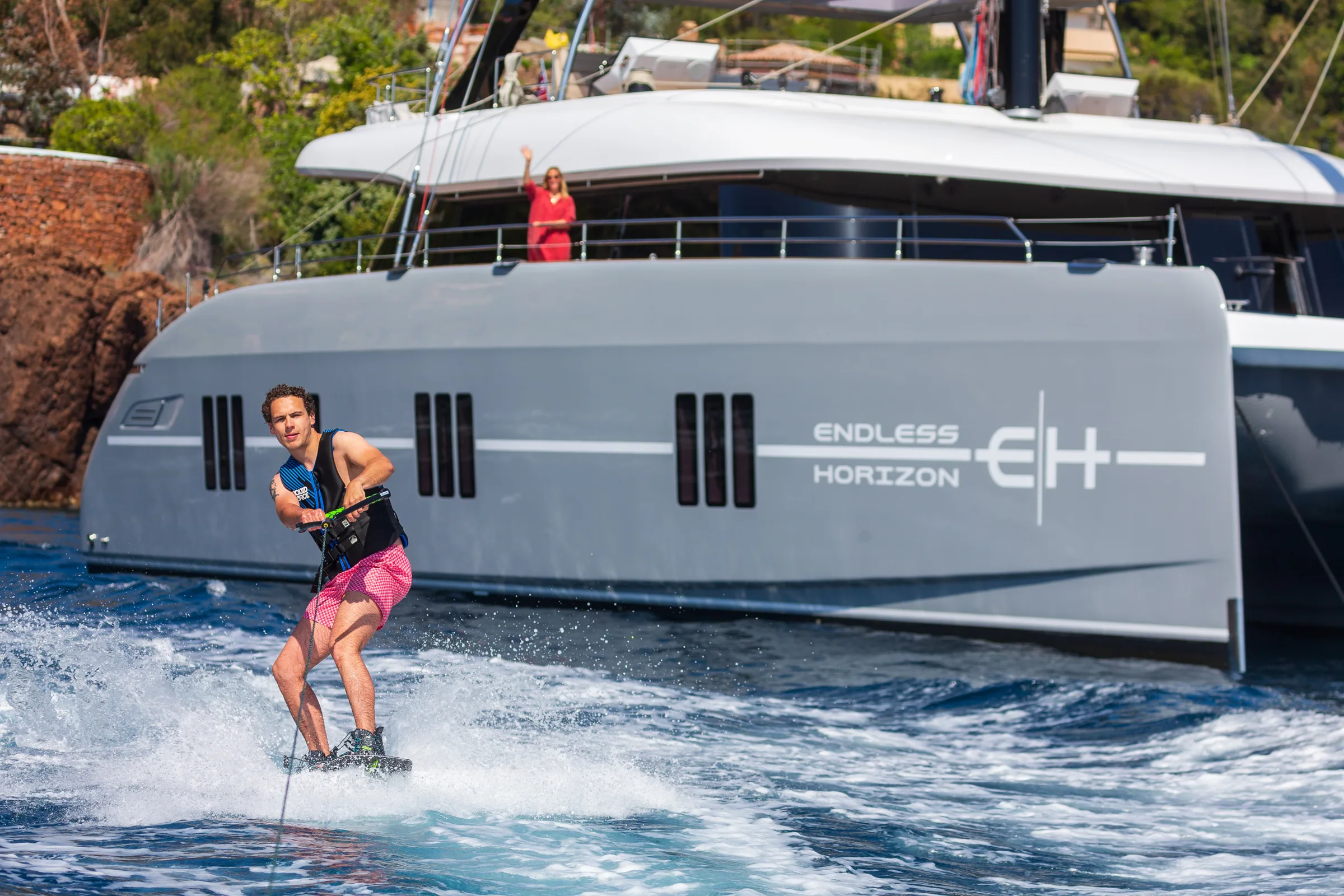 A guest wakesurfing off the swim platform of the Sunreef 80