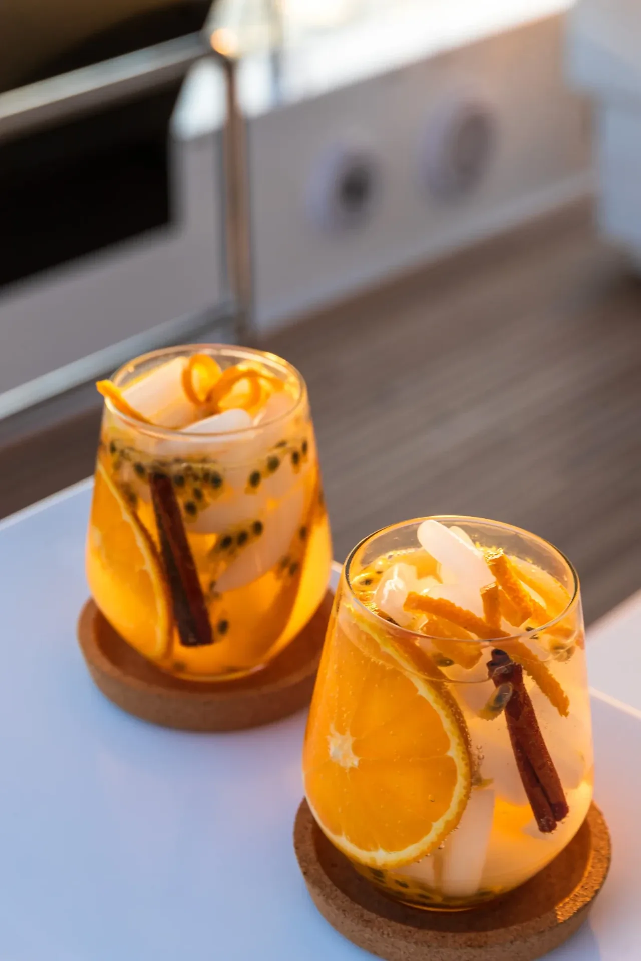 Two citrus and passionfruit cocktails on the flybridge bar in evening light