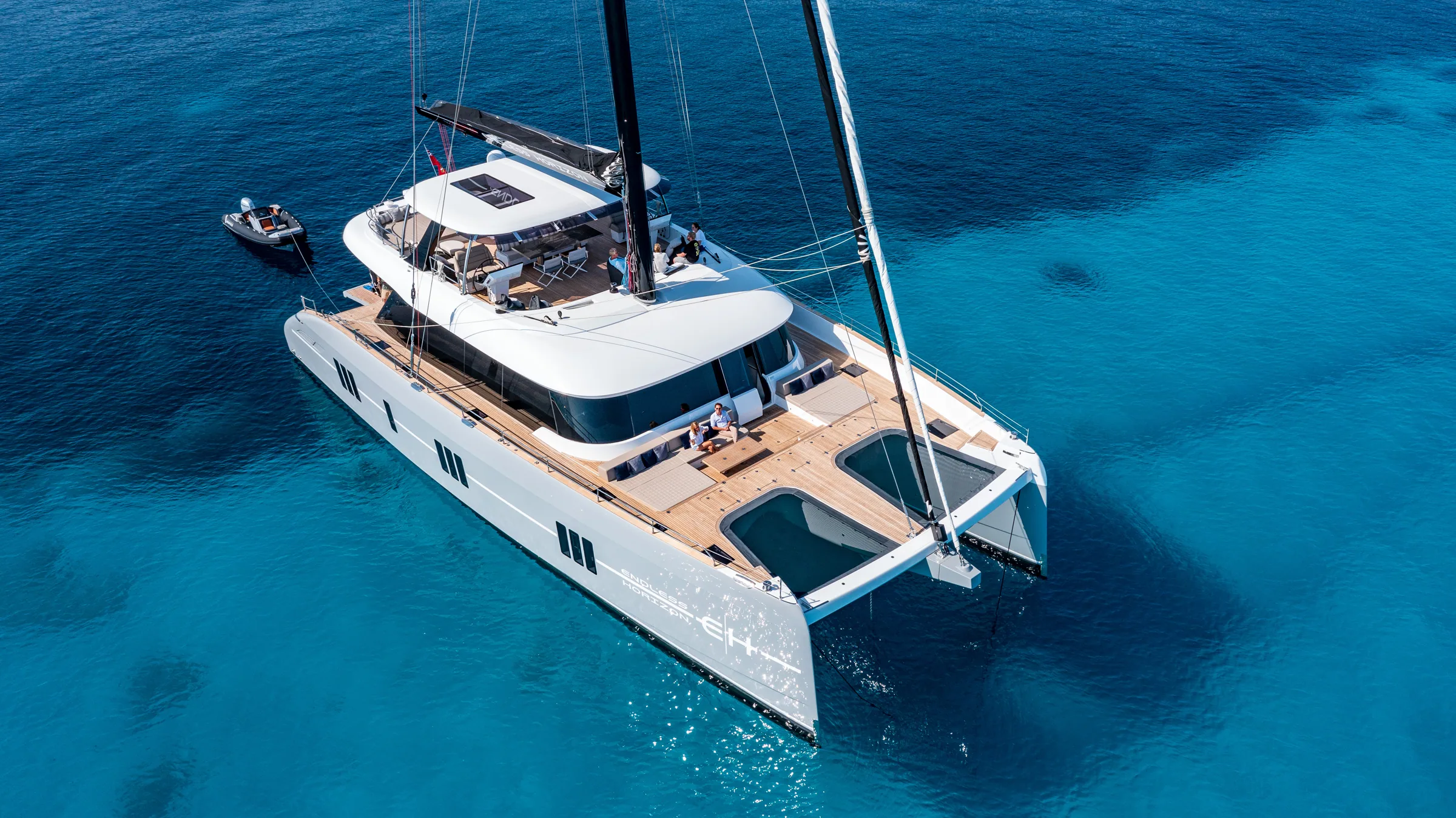 Endless Horizon II, a Sunreef 80 sailing catamaran, at anchor over deep turquoise water seen from the air