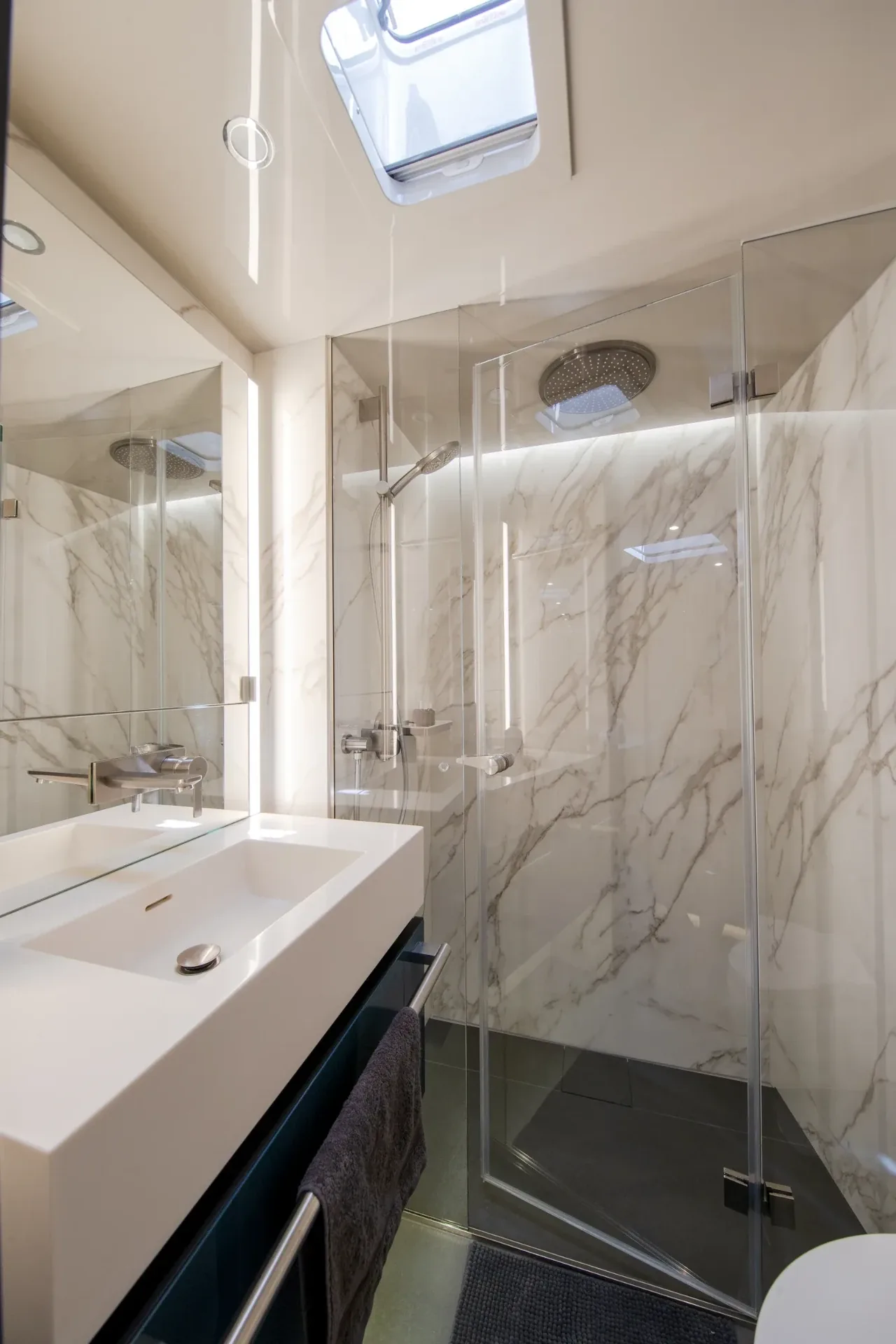 Marble ensuite with a glass walk-in shower and overhead hatch